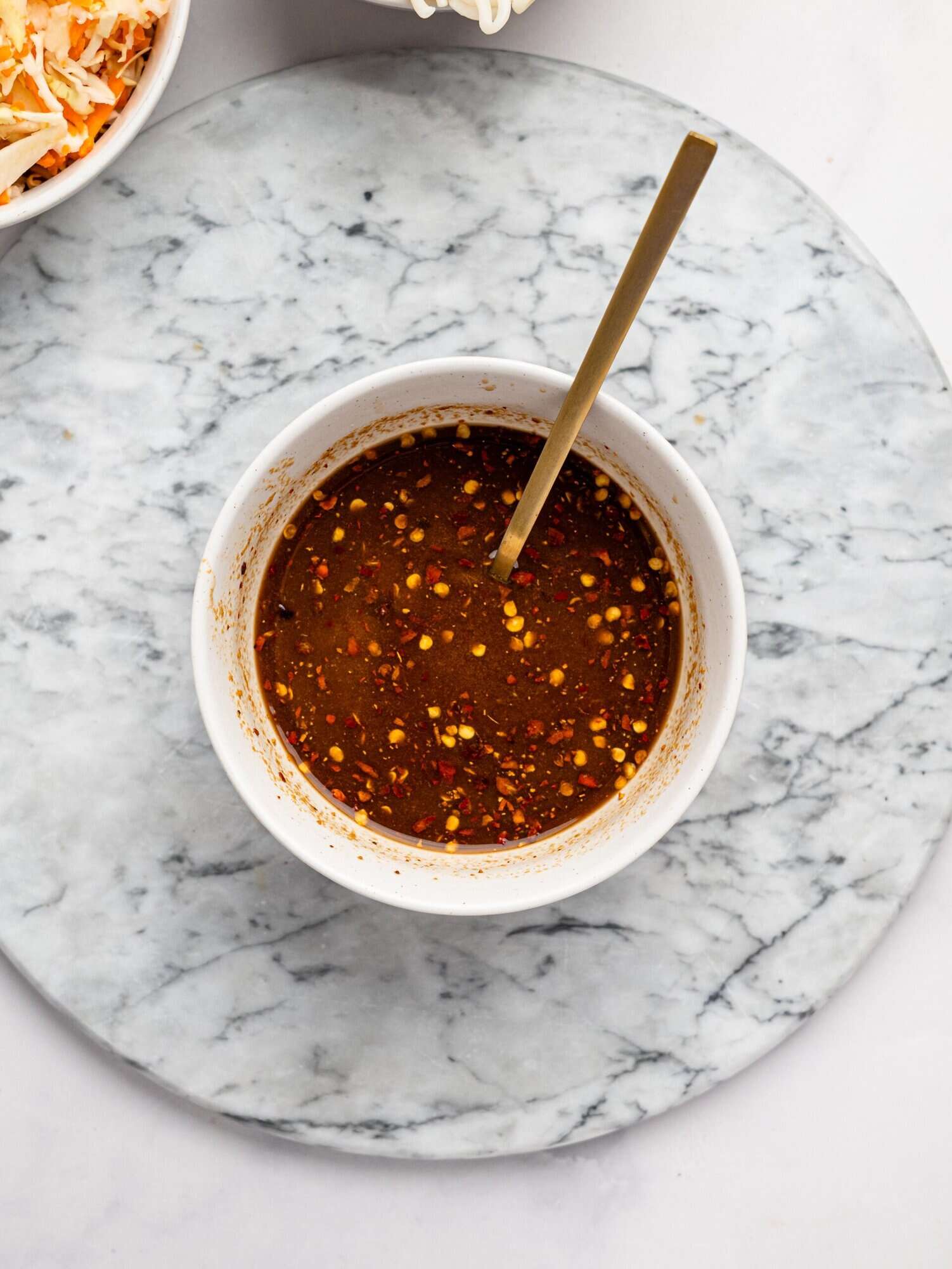 Spicy peanut butter sauce in a small white bowl.