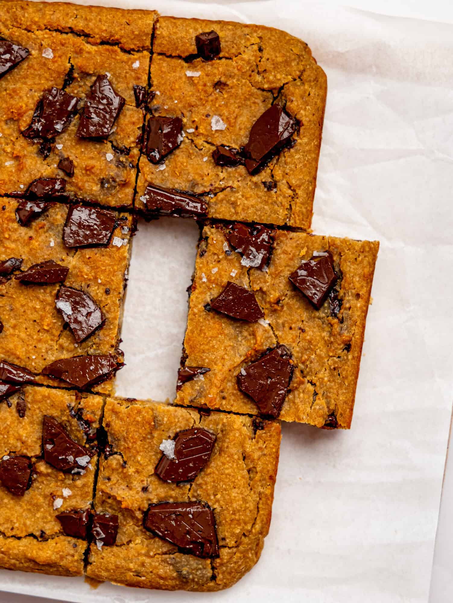 Bird's eye view of healthy cookie bars on a sheet of white parchment paper.