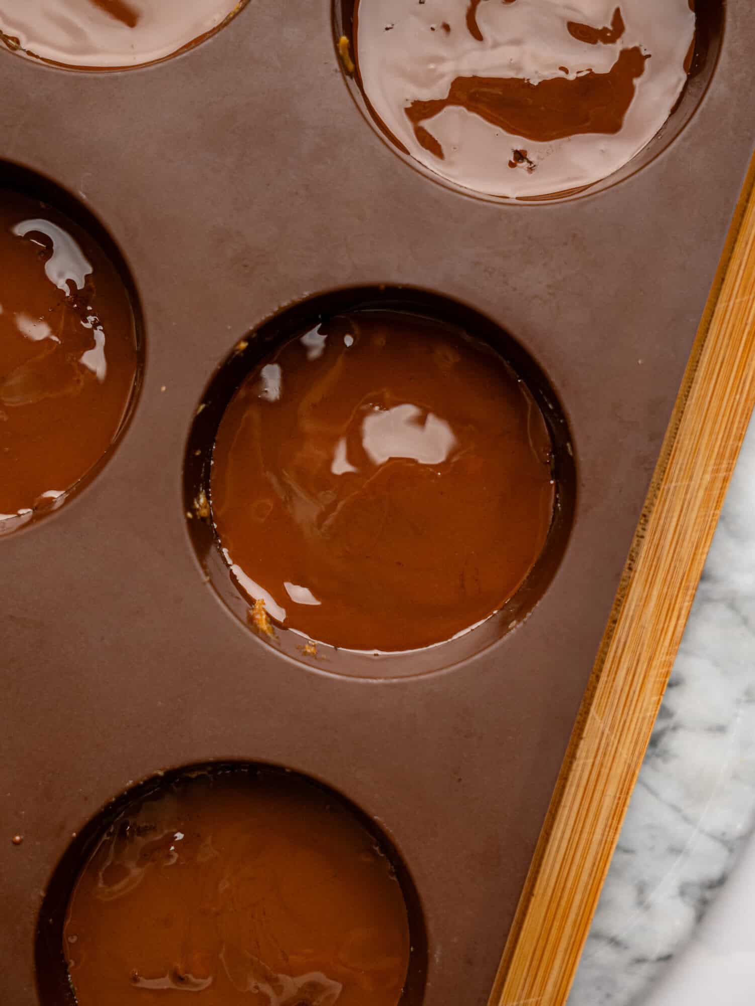 Millionaires' Weetbix Cups in a brown silicone muffin mould before chilling.