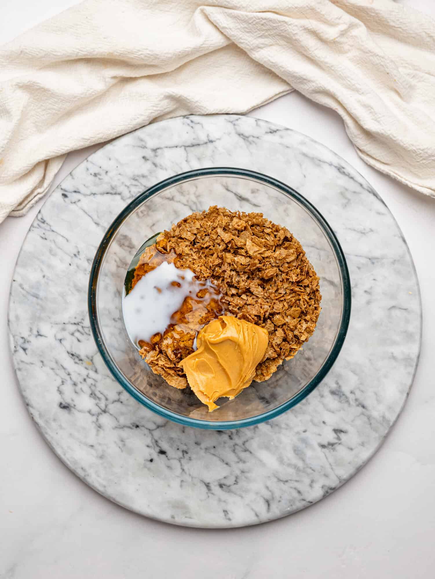 Weetbix Millionaires' Cups base ingredients in a glass bowl.