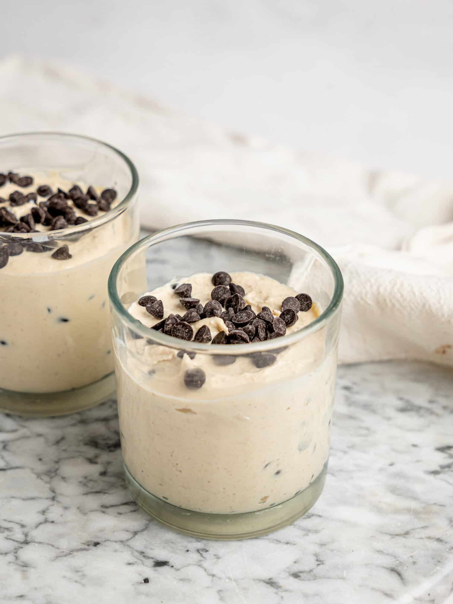 Close-up of Cottage Cheese Cookie Dough Mousse with dark chocolate chips served in a glass dessert cup.
