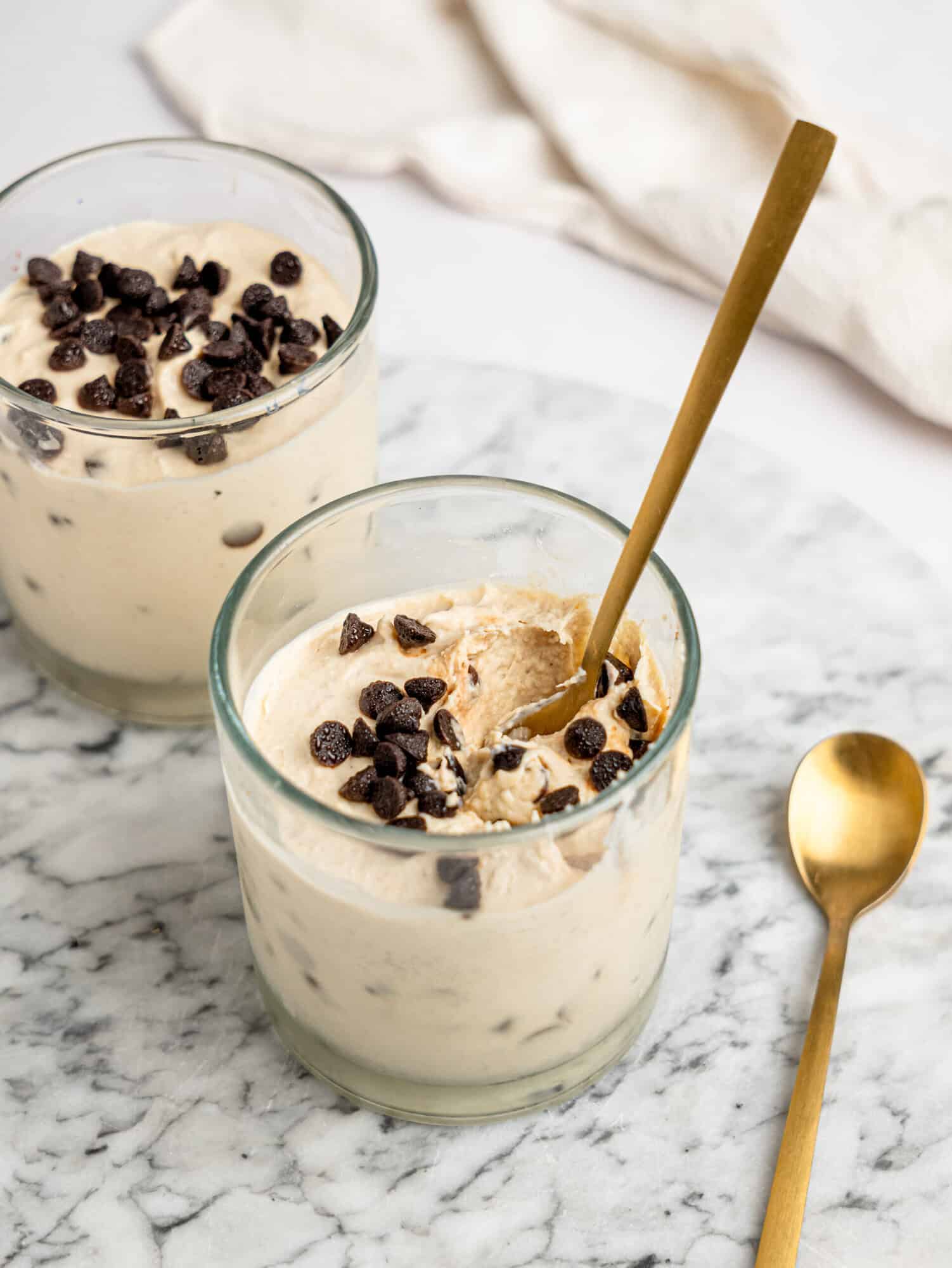 Ingredients needed to make Cottage Cheese Cookie Dough Mousse including cottage cheese, nut butter, oat flour, coconut sugar, vanilla extract, and dark chocolate chips.