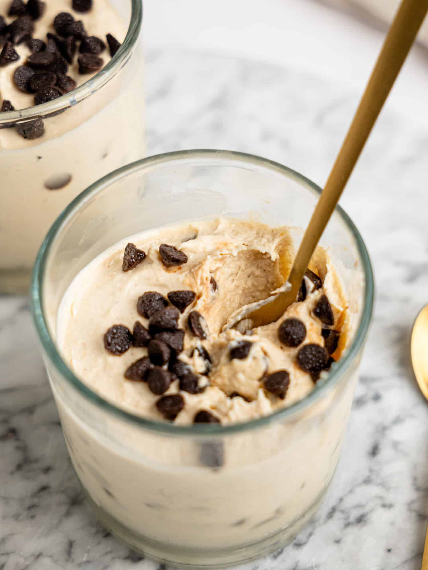 Creamy Cottage Cheese Cookie Dough Mousse served in glass dessert cups and topped with dark chocolate chips.