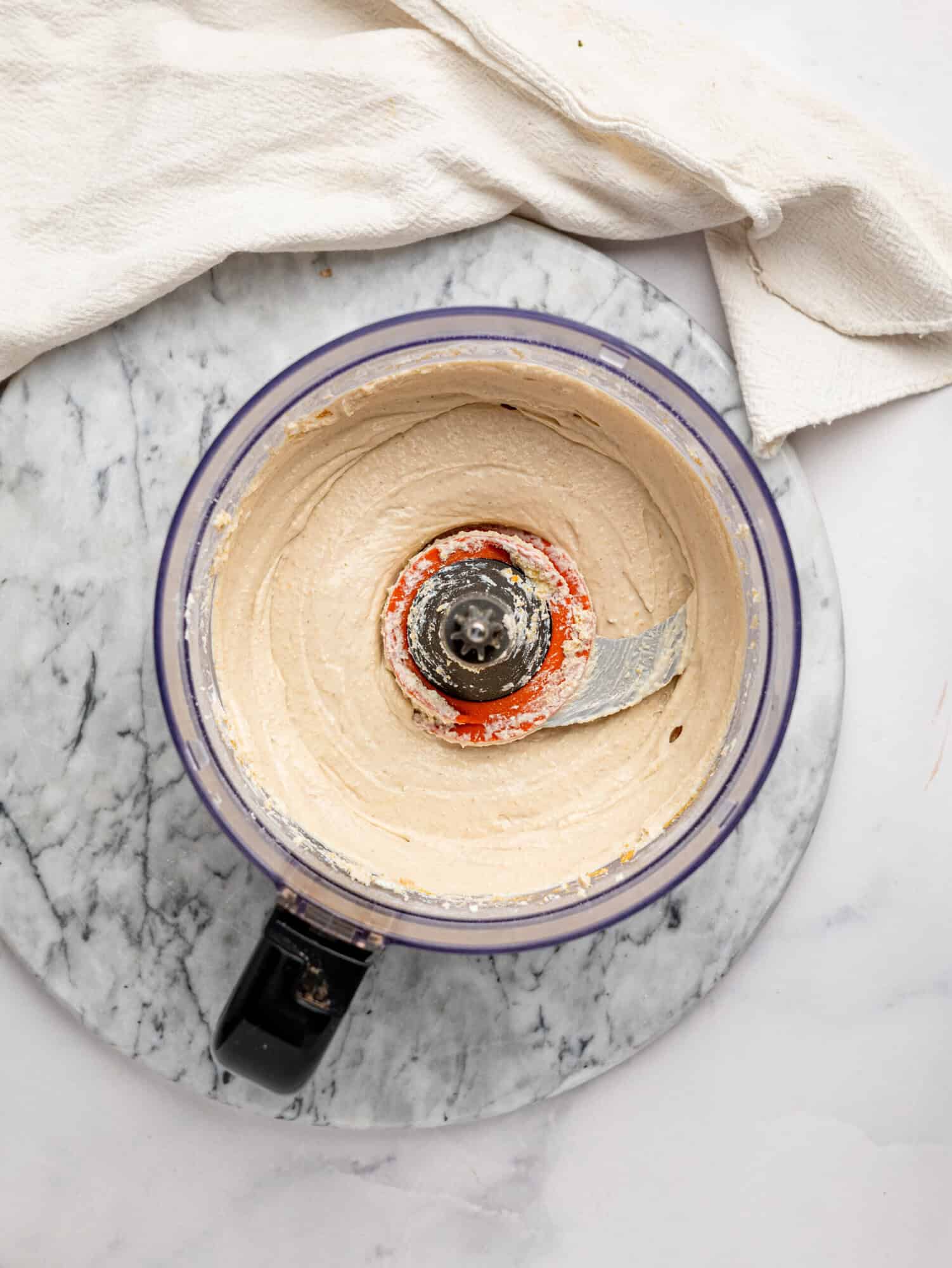 Overhead view of creamy blended Cottage Cheese Cookie Dough Mousse mixture with chocolate chips folded throughout.