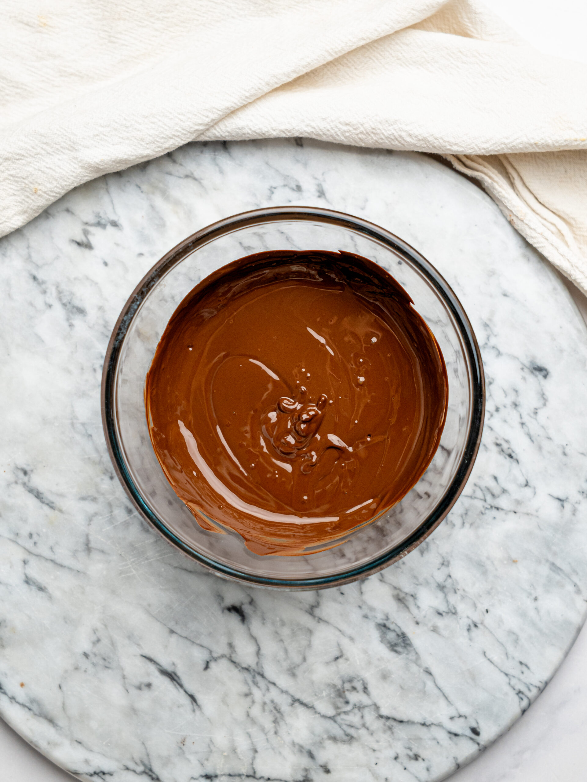 Bowl of melted dark chocolate used for coating the no-bake brownie bites.