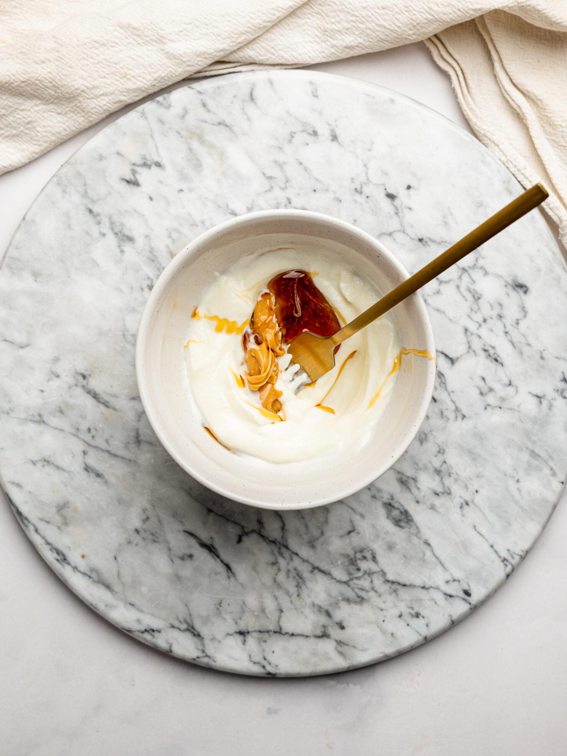 Greek yogurt, peanut butter, and honey in a bowl before being mixed together for overnight Weetbix.