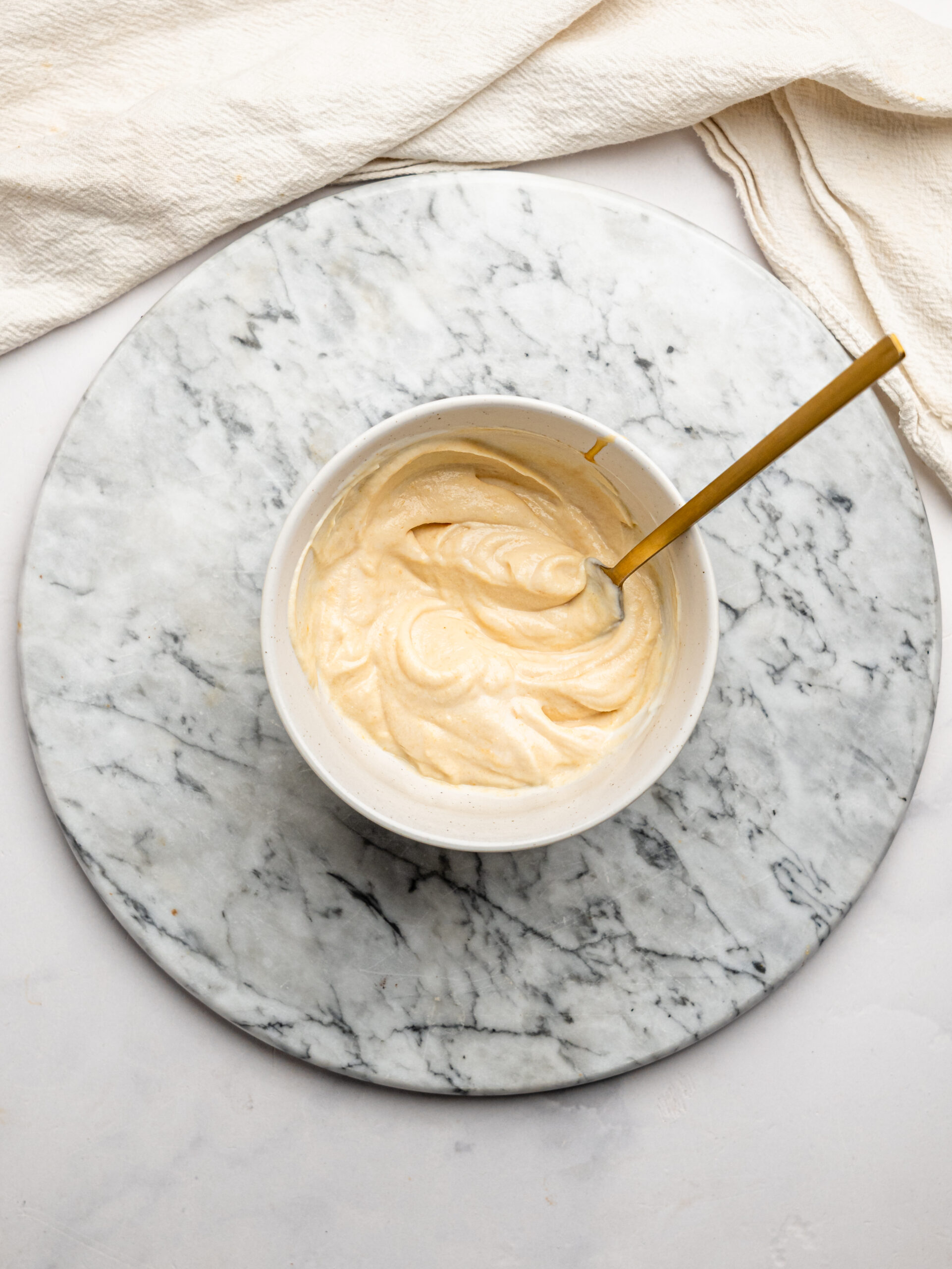Creamy peanut butter yogurt mixture stirred until smooth for PB&J Overnight Weetbix.