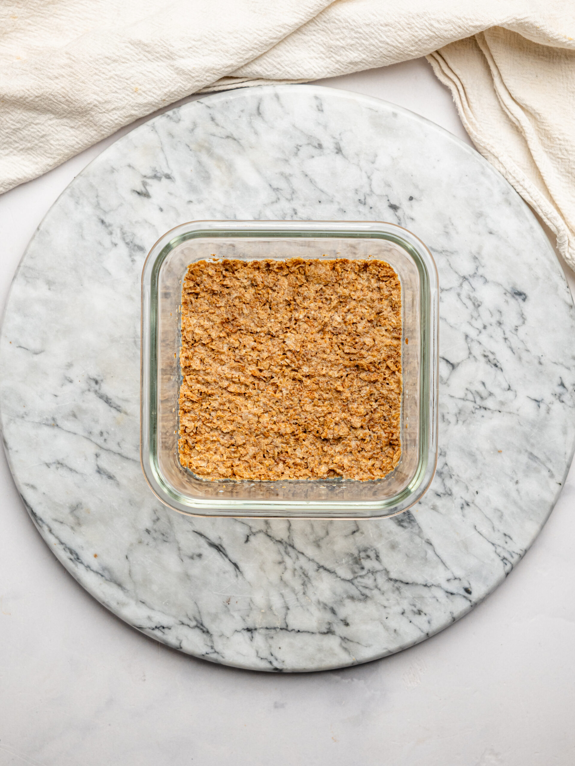 Crushed Weetbix mixed with milk and pressed into a glass container to form the overnight Weetbix base.