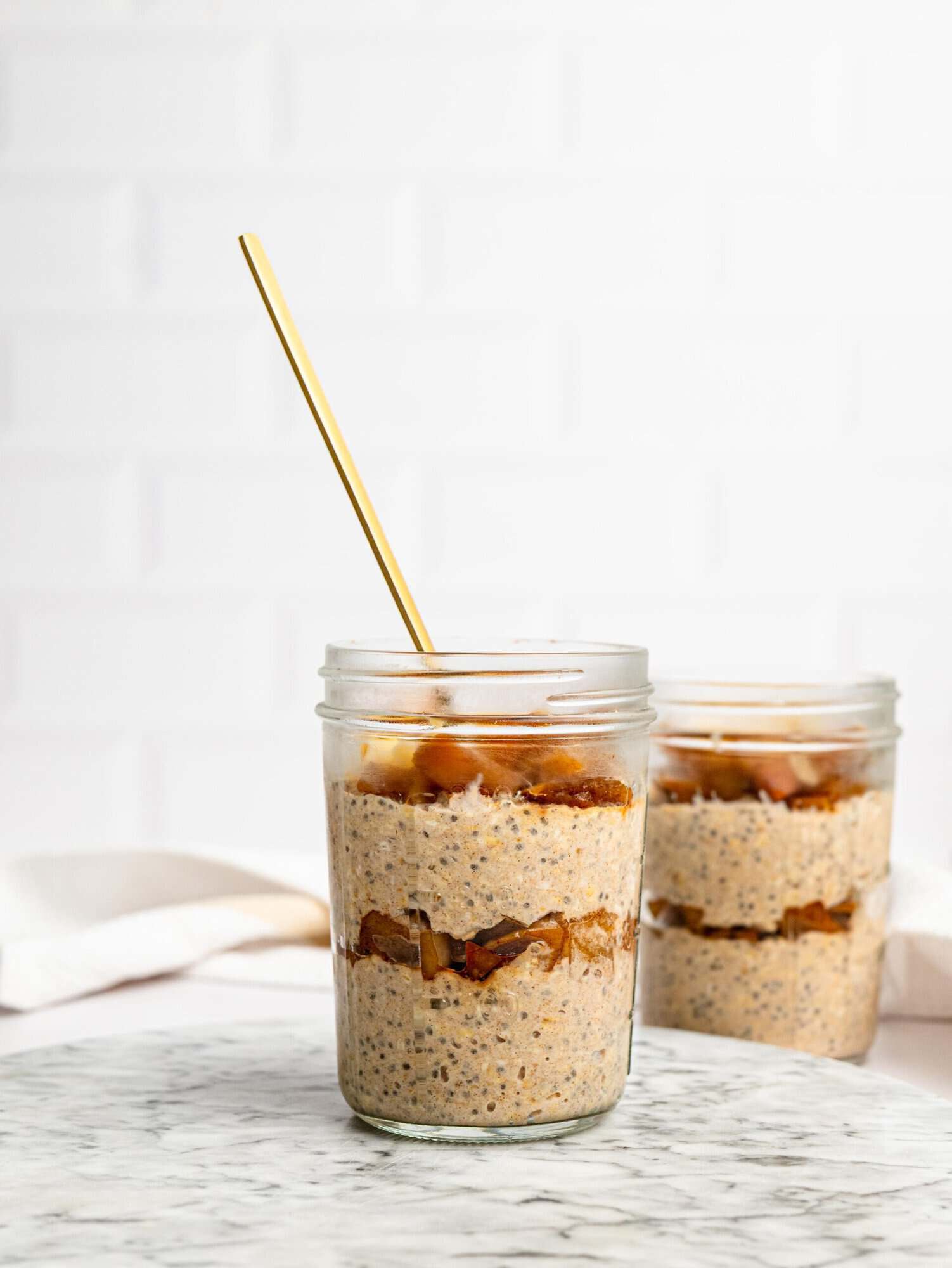 Layered Apple Pie Overnight Oats with cinnamon apples and sliced almonds.