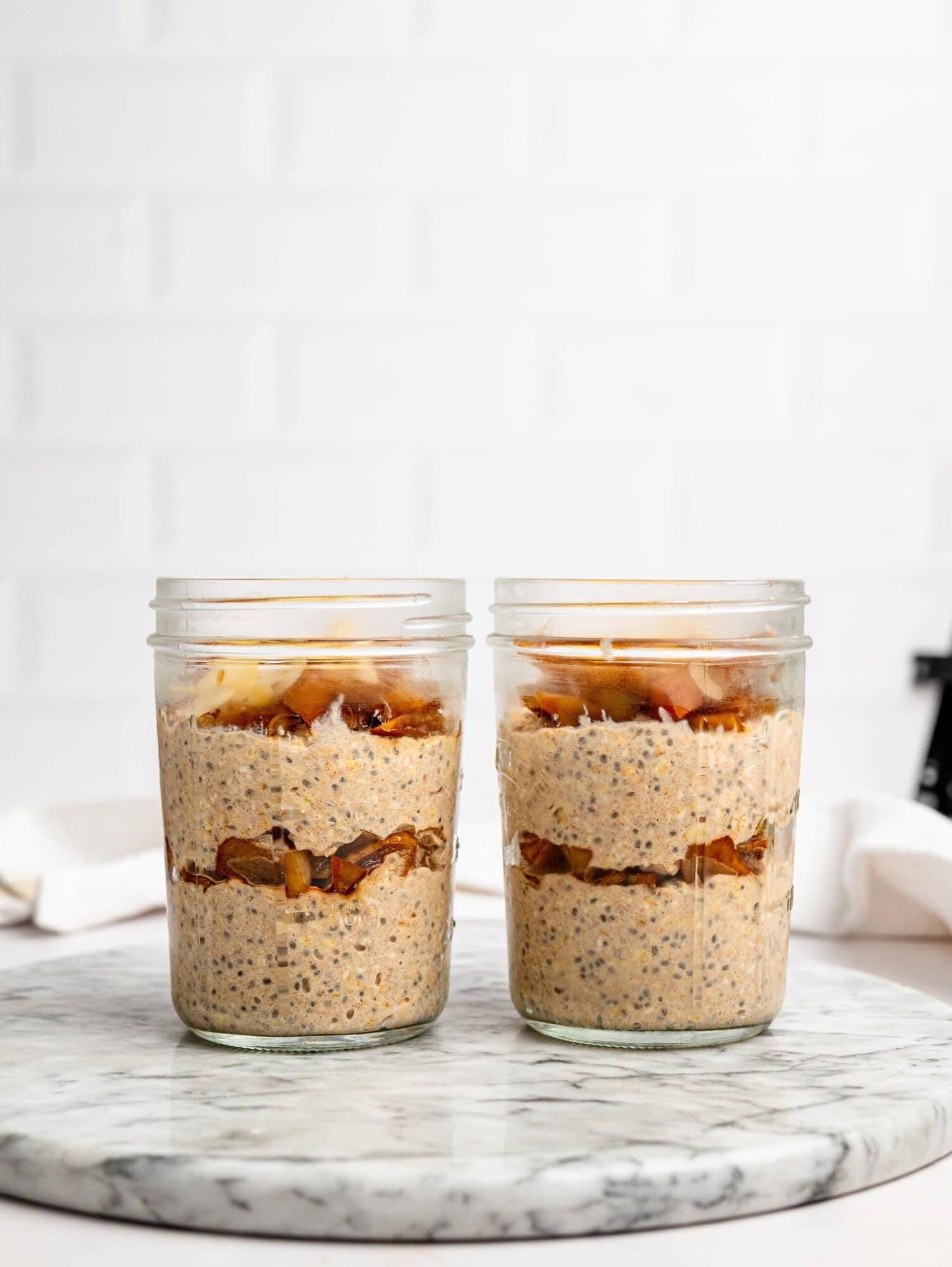 Two jars of healthy Apple Pie Overnight Oats ready for meal prep.