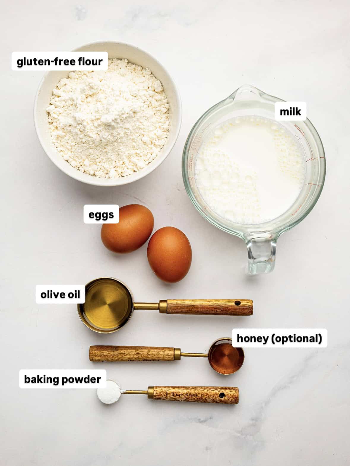 Ingredients for my Gluten Free Waffle Recipe, including gluten-free flour, eggs, milk, olive oil, honey, and baking powder.