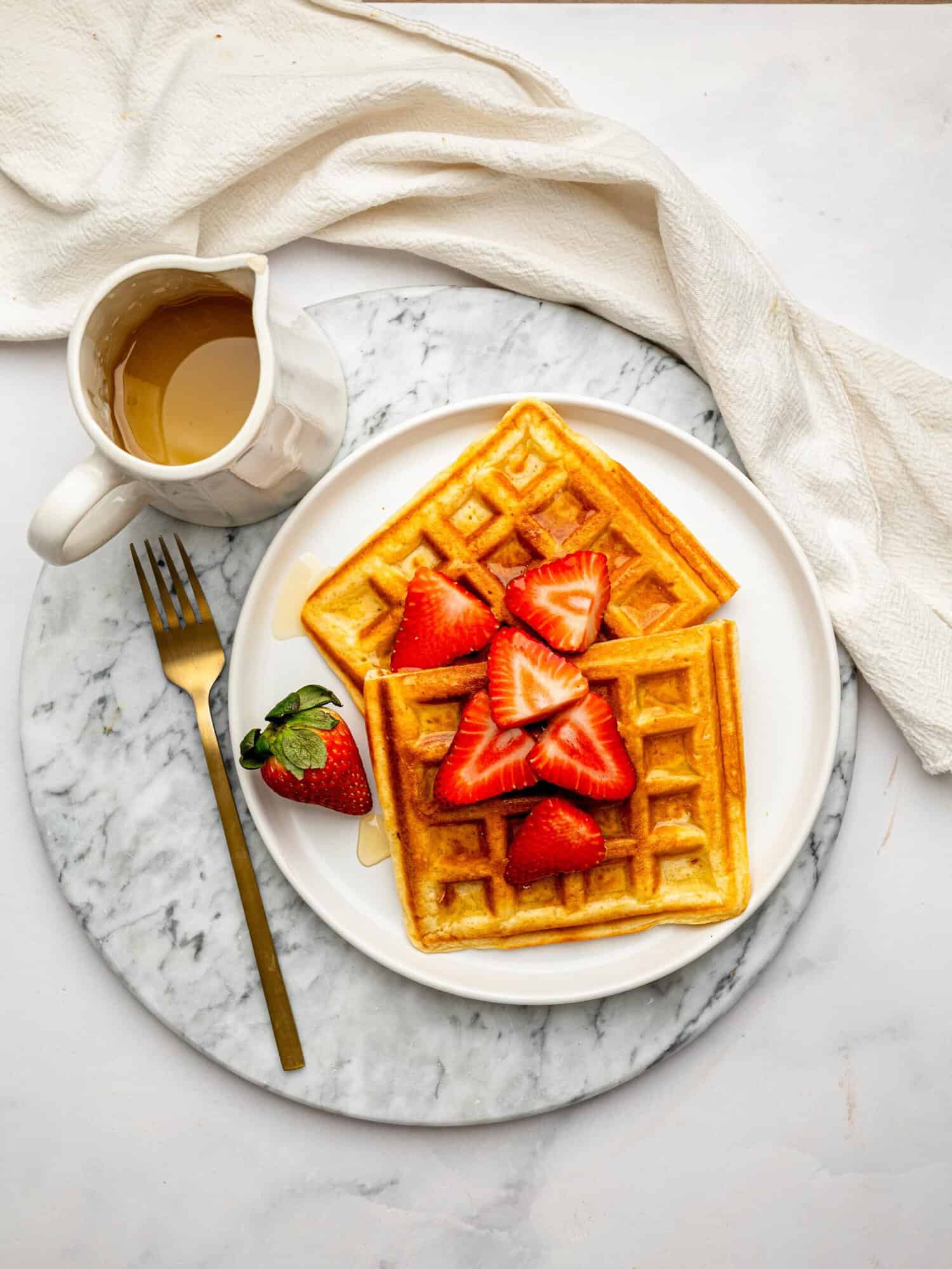 Easy gluten-free waffles served with strawberries and a drizzle of honey.