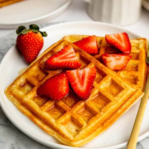The Best Gluten Free Waffle Recipe served with fresh strawberries and honey.