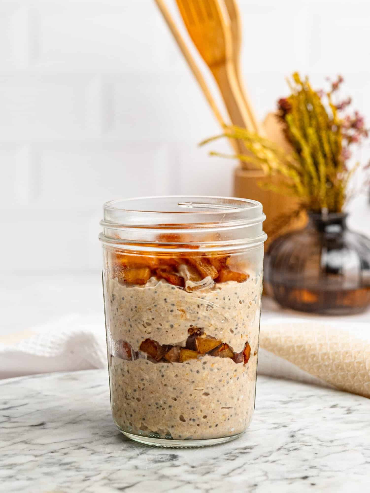 Layered Apple Pie Overnight Oats with cinnamon apples and sliced almonds.