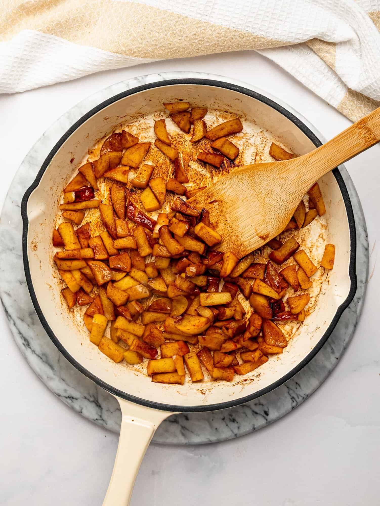Caramelized cinnamon apples cooking in a skillet for Apple Pie Overnight Oats.