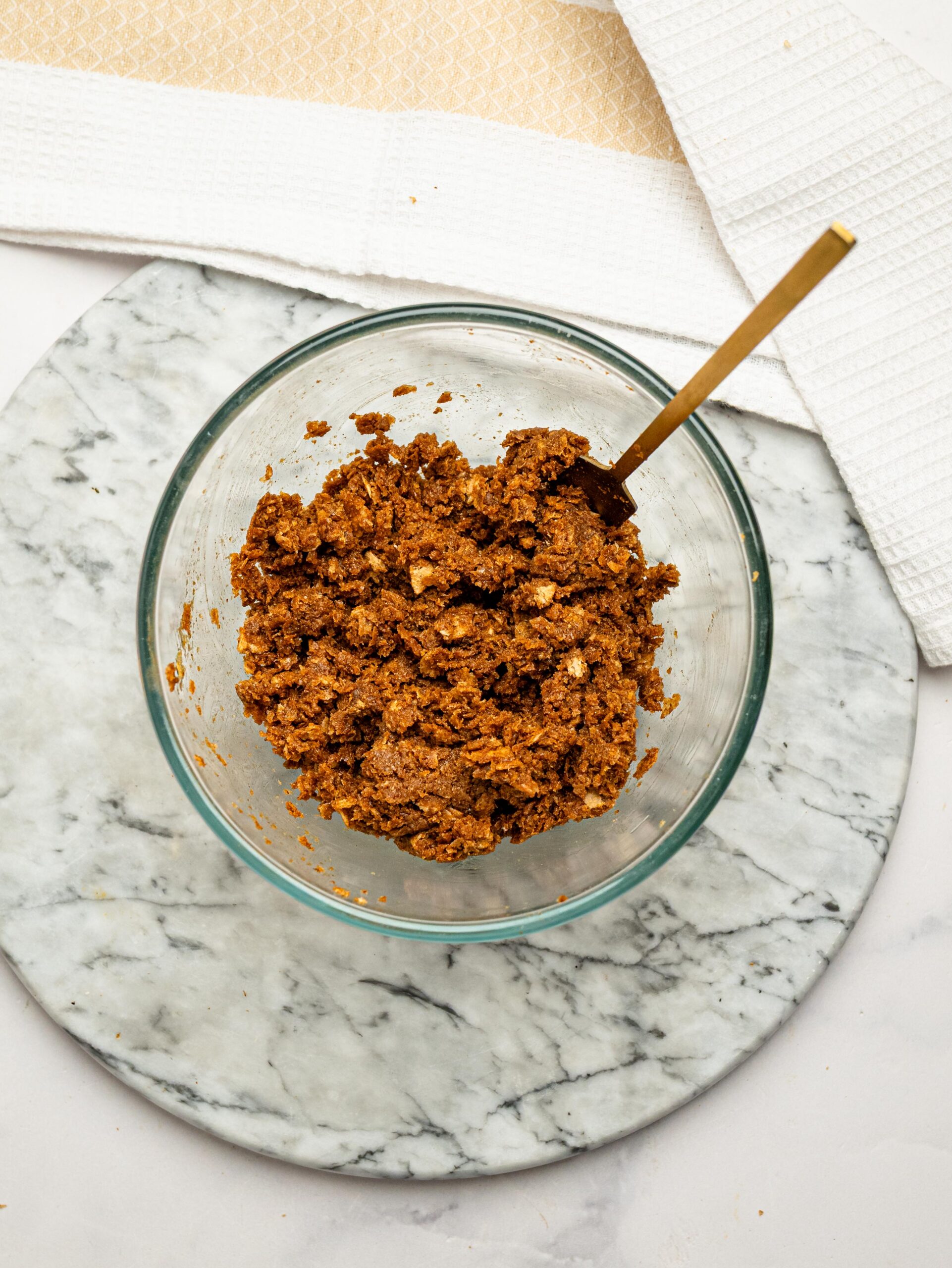 Coffee-soaked Weetbix mixture stirred together in a glass bowl before pressing into the muffin pan.