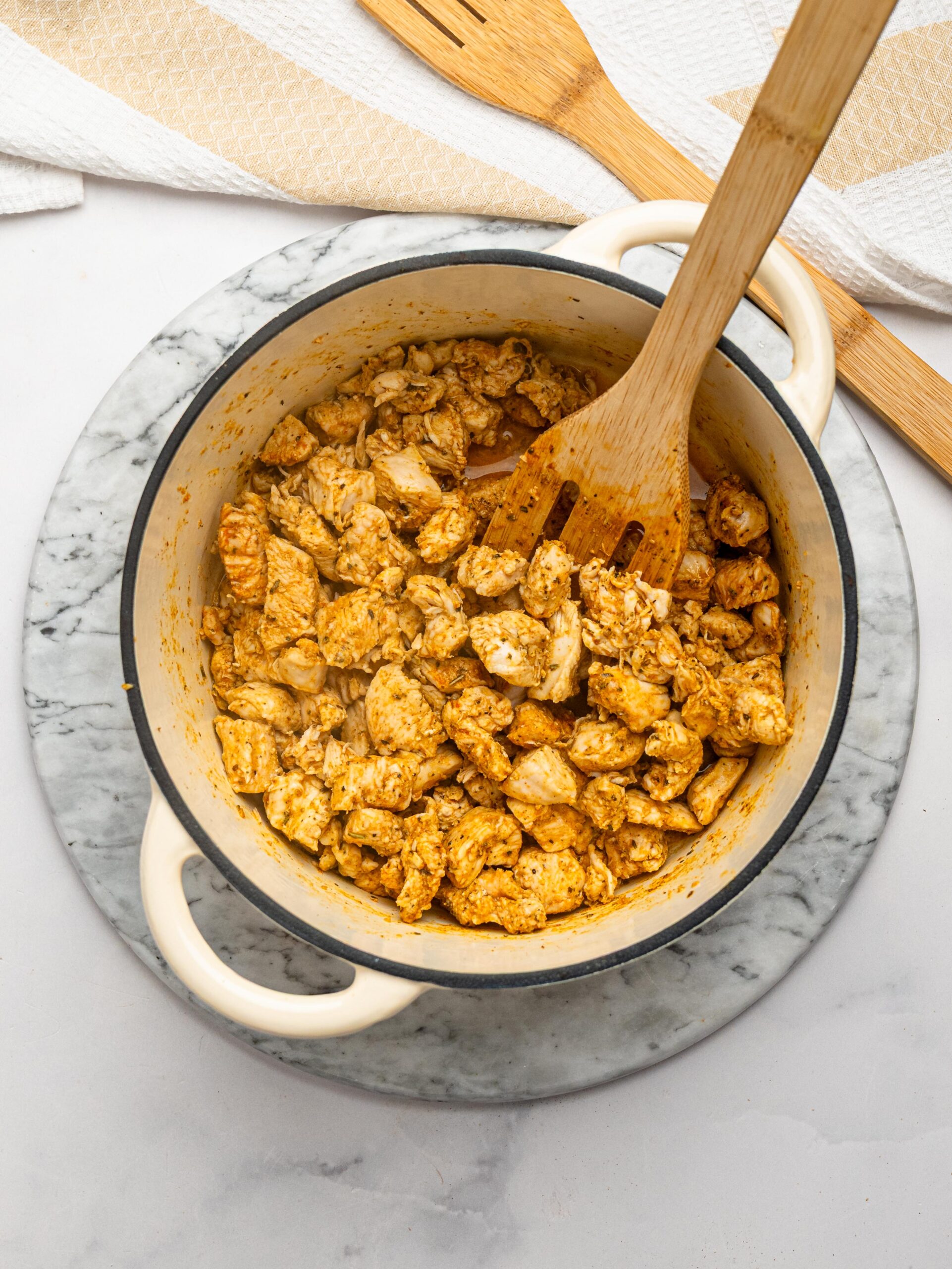 Seasoned chicken breast browning in a Dutch oven for one pot chicken pasta.