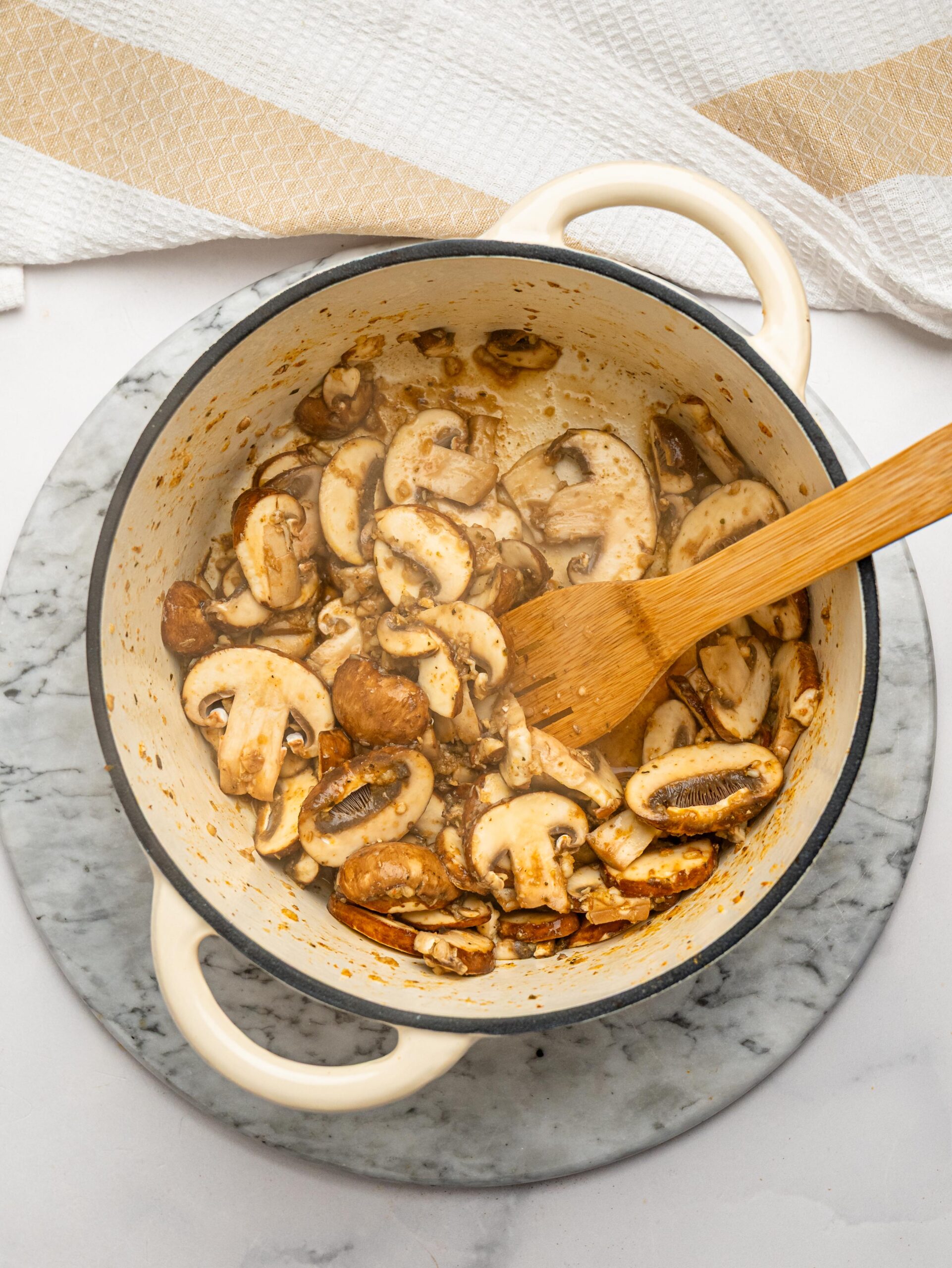 Sautéing mushrooms and garlic for creamy chicken mushroom mac and cheese.