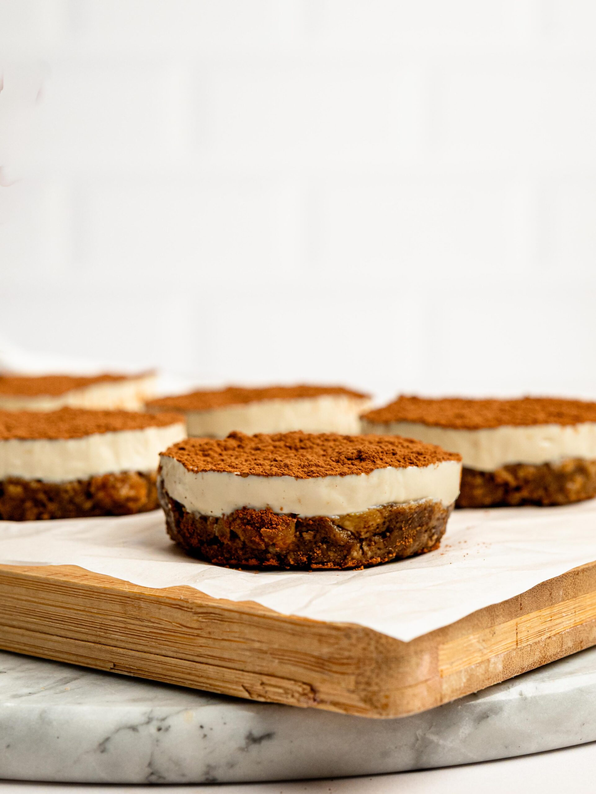 Side view of a Mini Tiramisu Cheesecake Weetbix Cup with a creamy cheesecake topping and coffee Weetbix base.