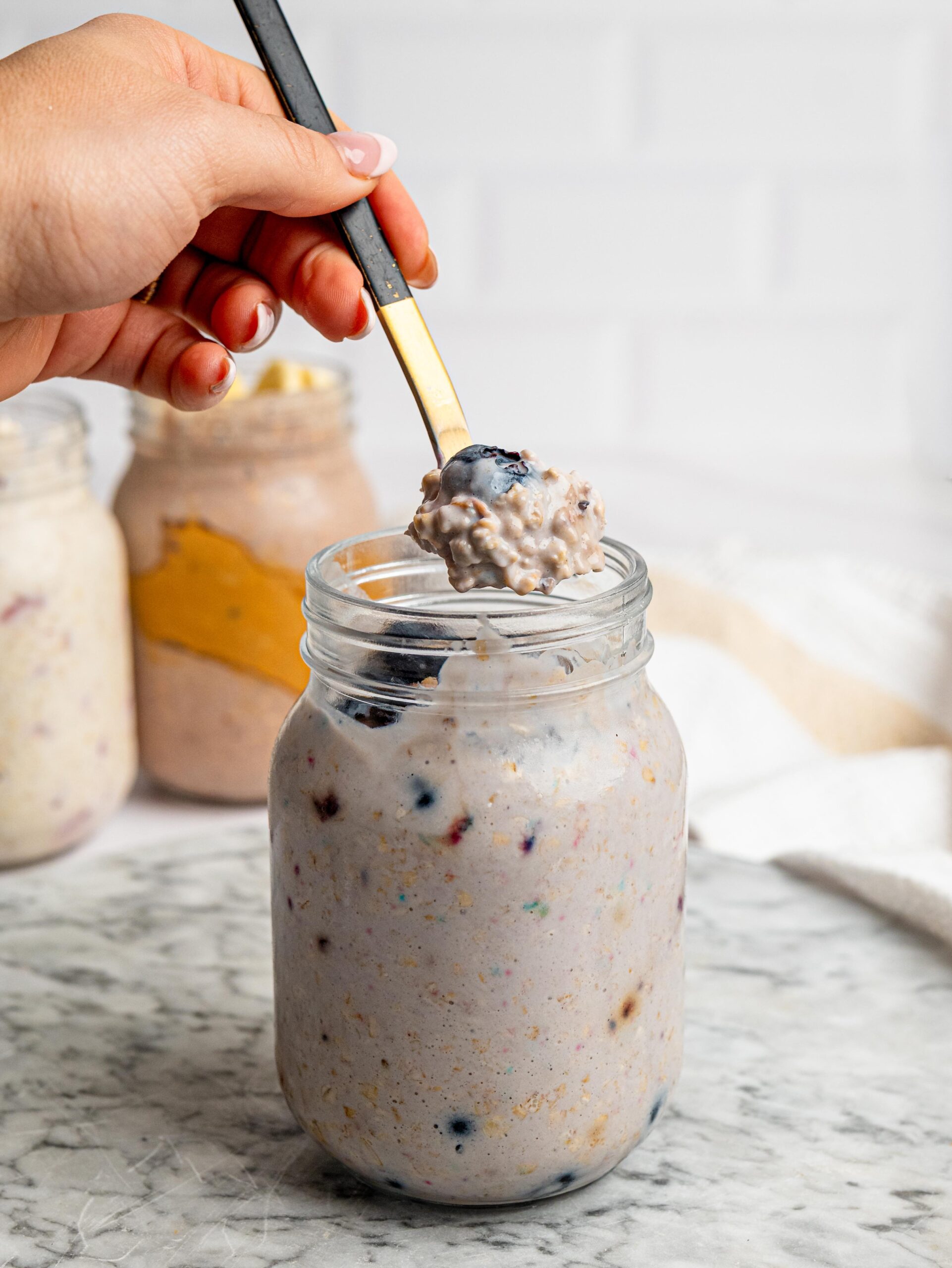 blueberry protein overnight oats Spoonful of blueberry protein overnight oats topped with fresh blueberries.