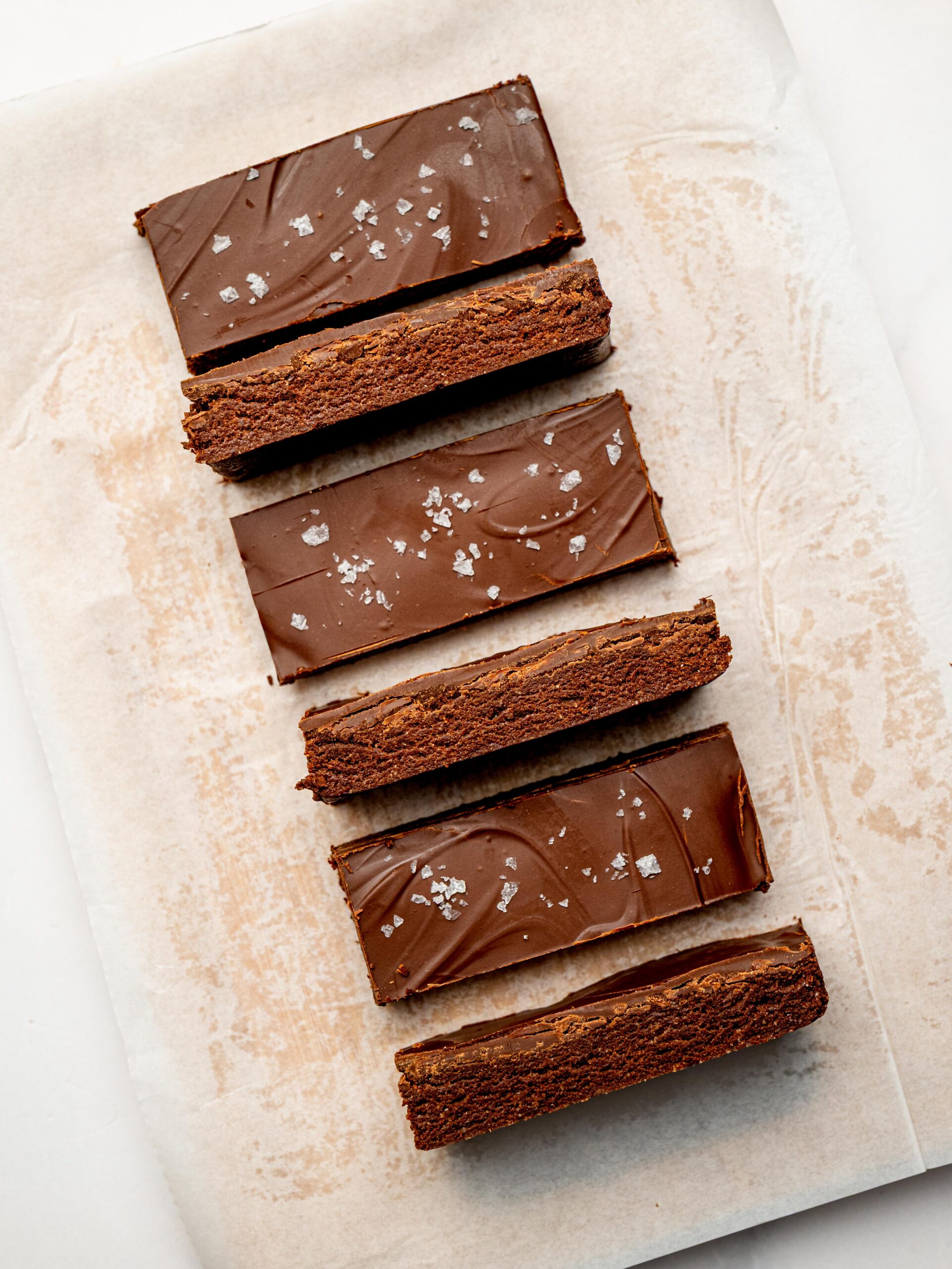 Close-up of thick chocolate protein bars with a fudgy texture and dark chocolate topping.