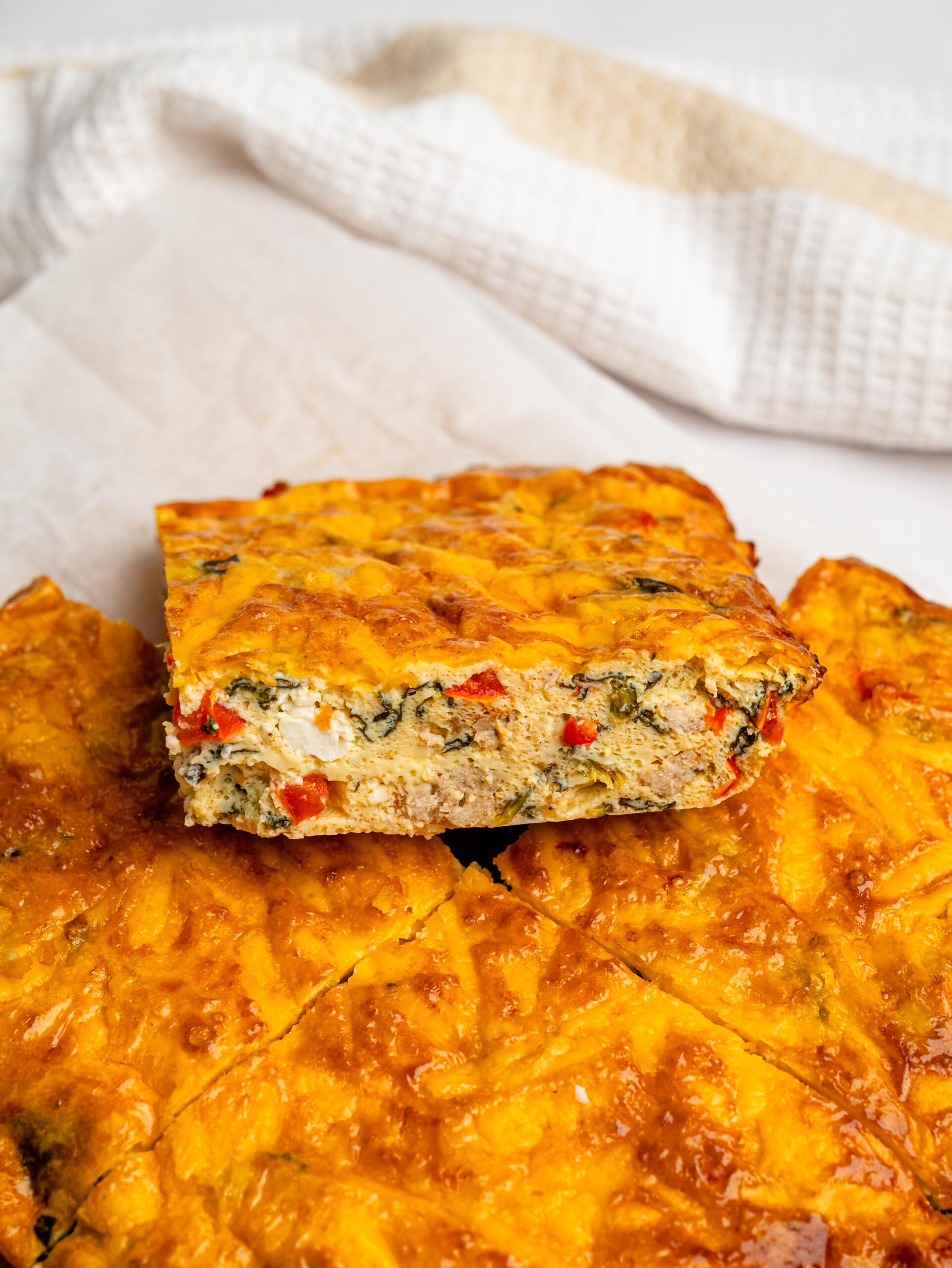 Close-up of a cheesy high protein egg bake with vegetables and sausage.