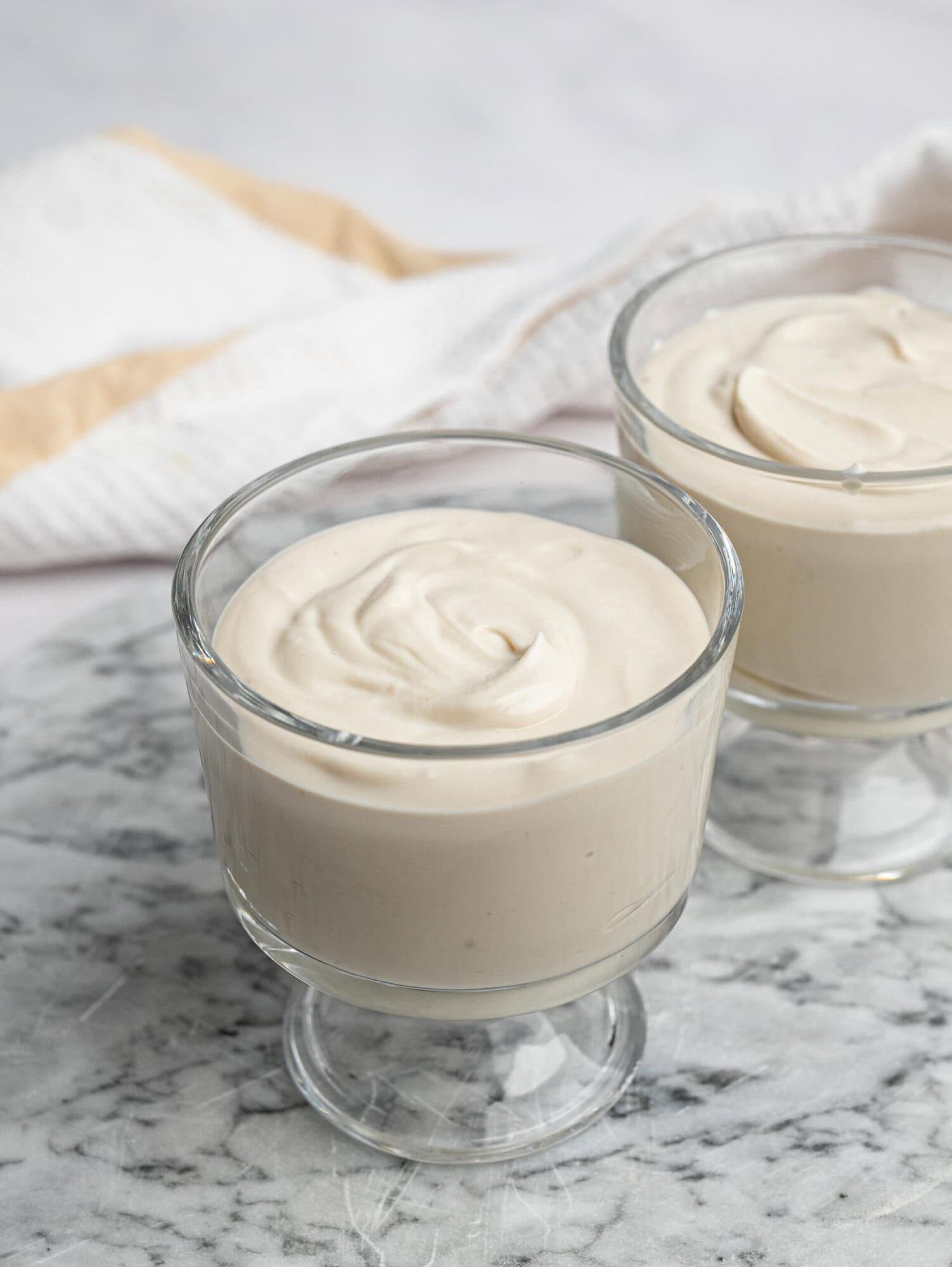 Creamy vanilla protein pudding in a glass dessert cup.