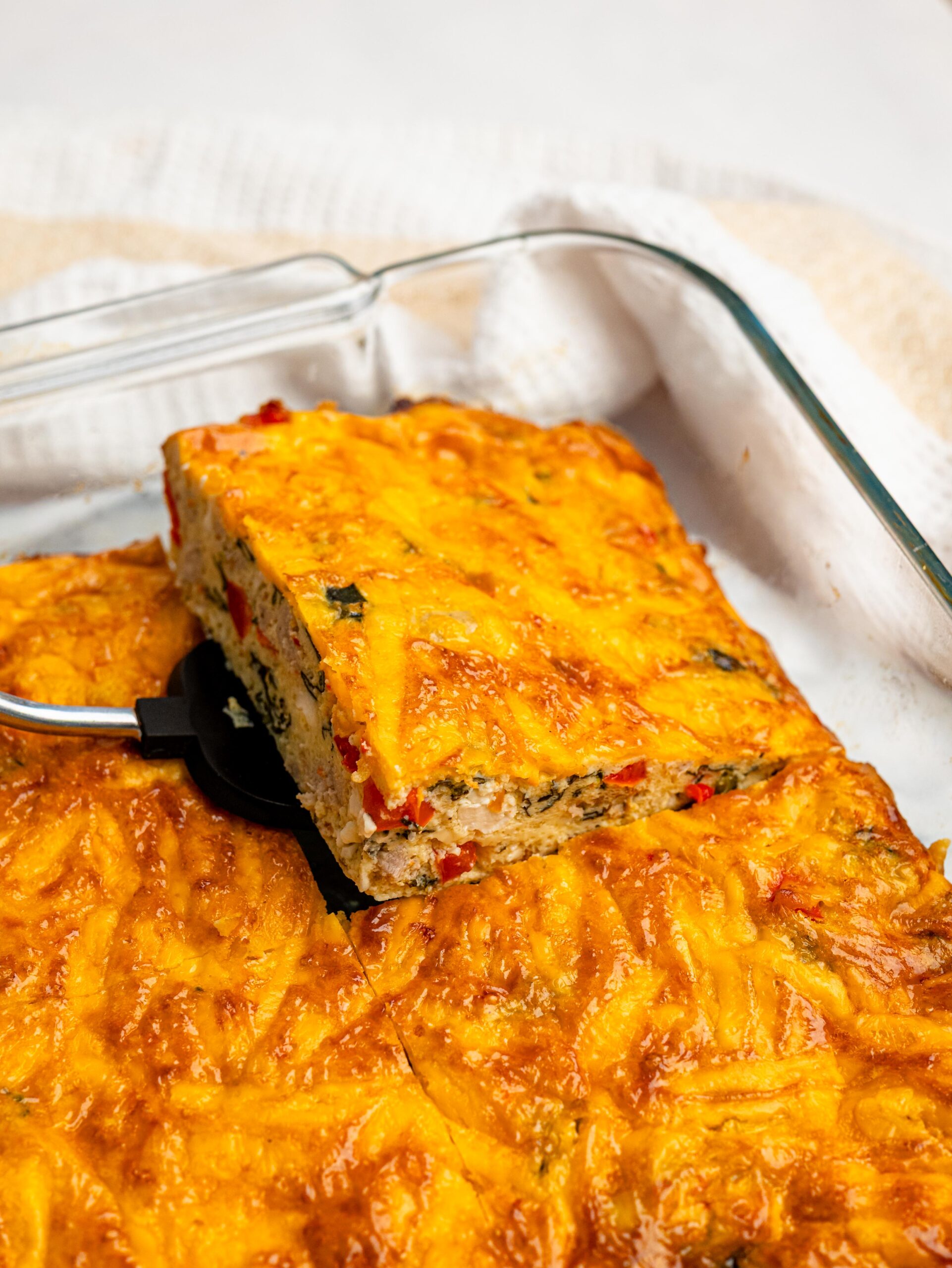 Slice of high protein egg bake being lifted from the baking dish.