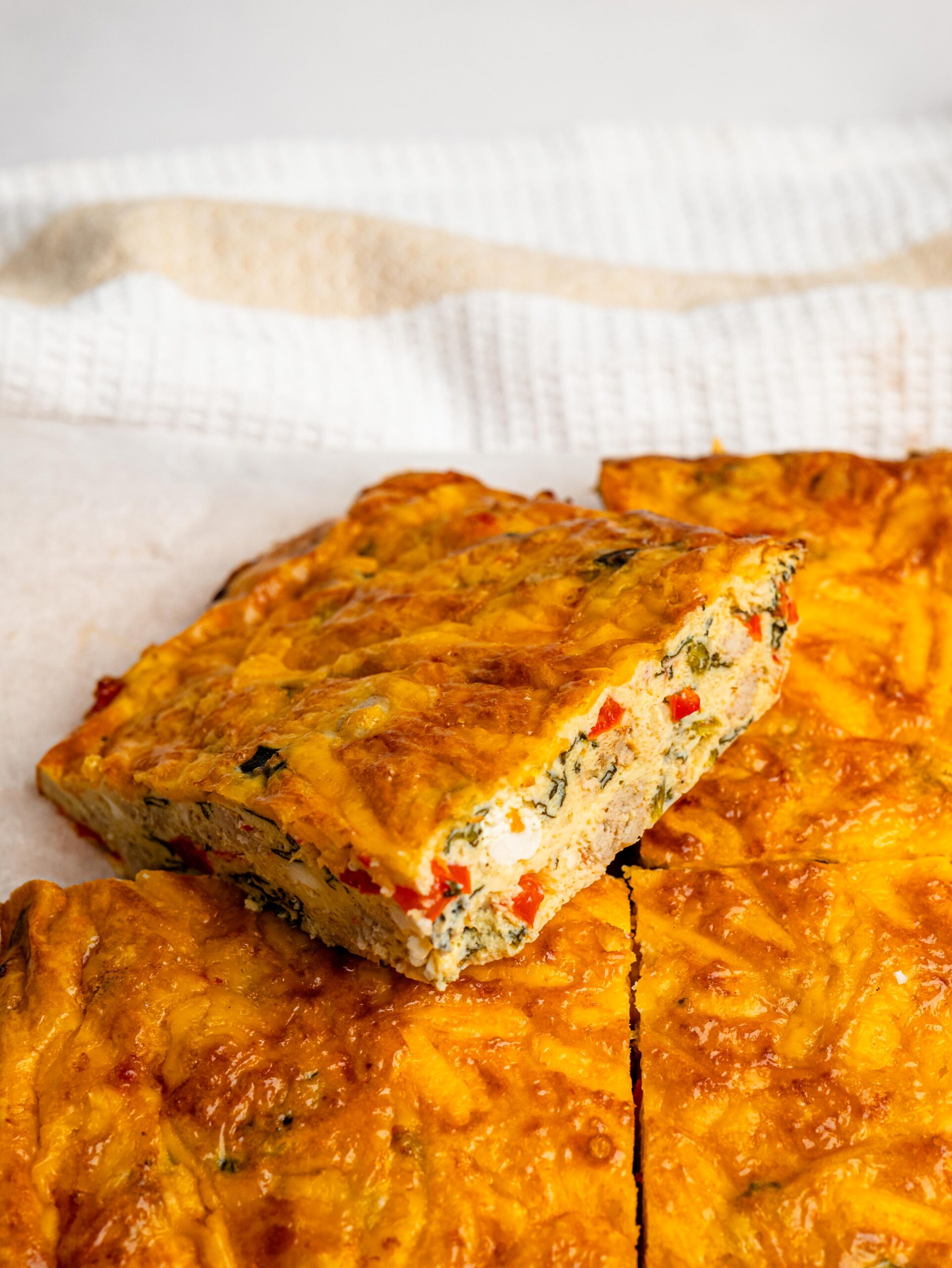Slices of cottage cheese egg bake showing the vegetables and sausage inside.