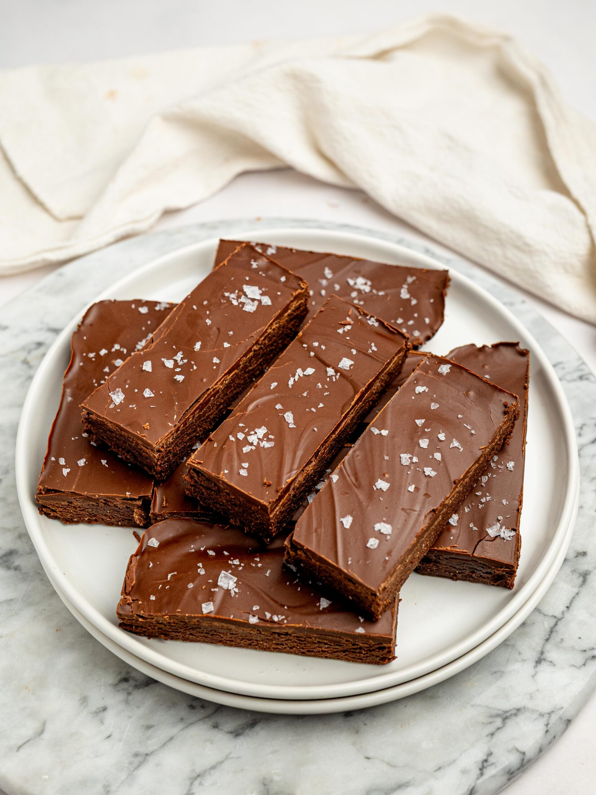 Plate of no bake chocolate protein bars finished with dark chocolate and sea salt.