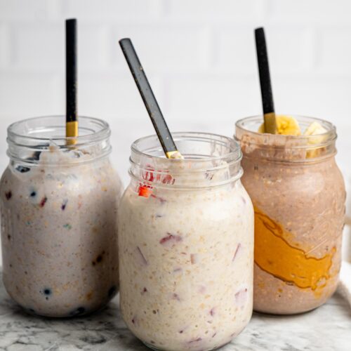 Three jars of overnight oats with protein powder in different flavors.
