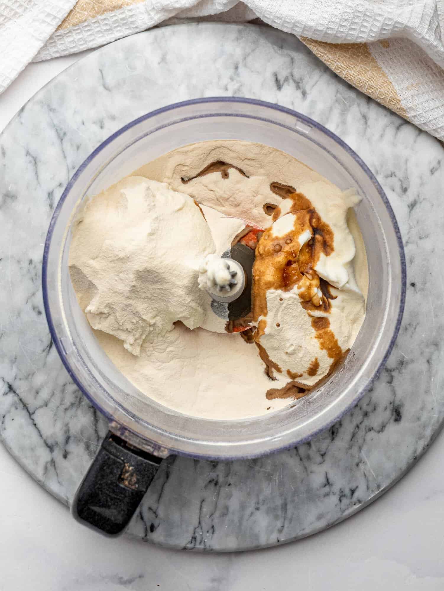 Cottage cheese, Greek yogurt and protein powder in a blender before mixing.