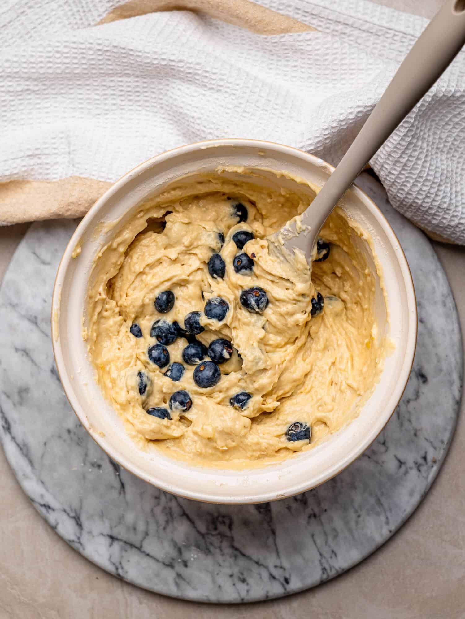 Thick blueberry muffin batter with fresh blueberries gently folded through.