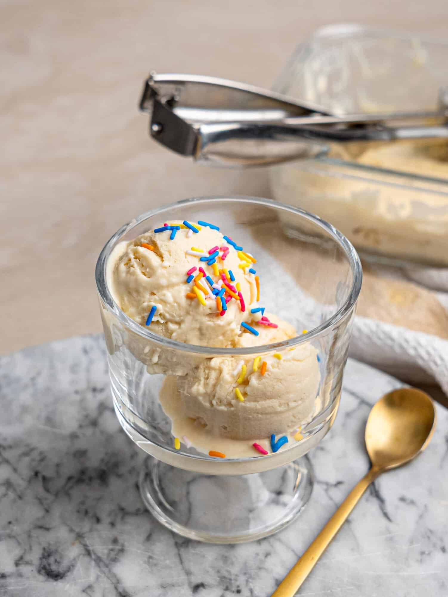 High protein ice cream served in a glass dessert bowl with colorful sprinkles.