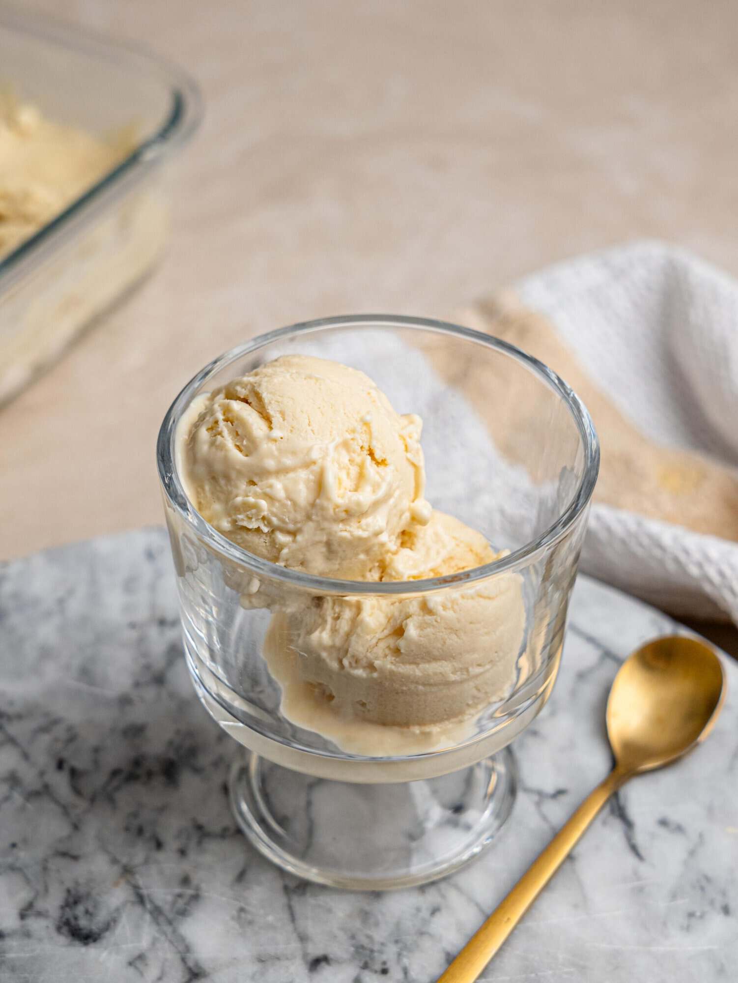 Two scoops of creamy vanilla protein ice cream served in a glass bowl.