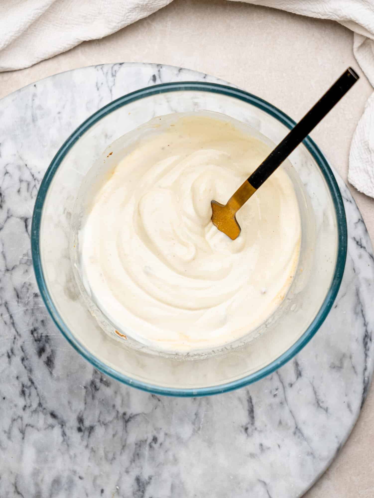 Greek yogurt, lemon juice, Dijon mustard and garlic powder combined in a glass bowl to make the creamy tuna salad dressing.